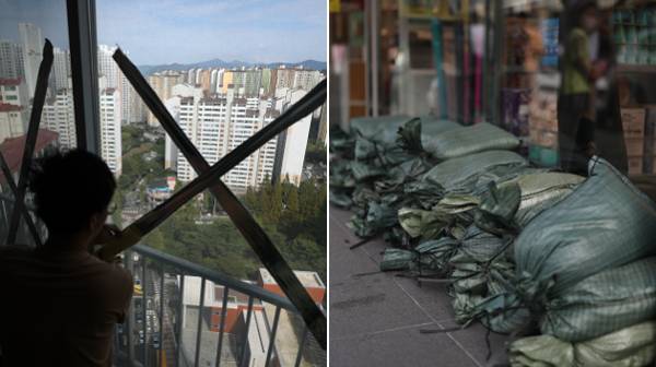 제11호 태풍 힌남노가 북상 중인 4일 전국 각지에서 태풍 피해를 막기 위한 여러 조치가 이뤄졌다. 경남 창원시 마산합포구의 한 아파트 주민이 유리창에 테이프를 붙이는 모습, 마산합포구 한 상가 앞에 쌓여 있는 모래주머니(왼쪽부터). 마산합포구는 2003년 태풍 매미 때 큰 피해를 보았다. 연합뉴스