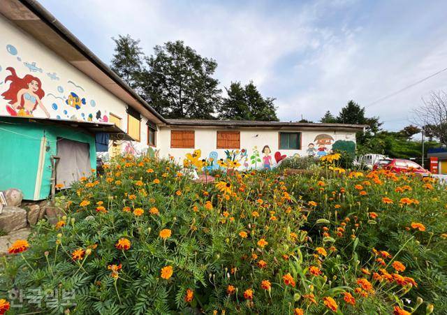 모운동 마을의 허름한 주택이 화사한 꽃밭과 동화 그림으로 장식돼 있다.