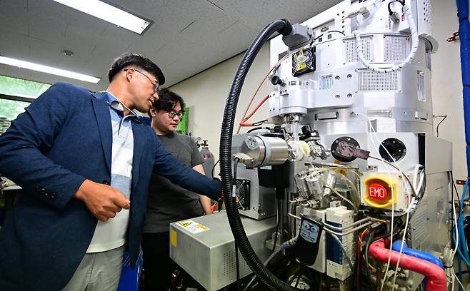 정진욱 한양 원자수준공정 및 플라즈마 연구센터장(왼쪽)과 연구진이 폴리 실리콘 식각 장치를 살펴보고 있다.