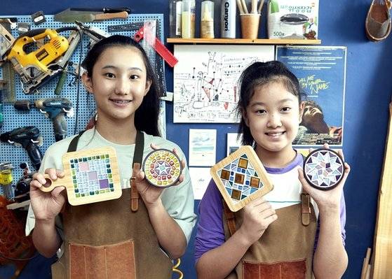 박민아(왼쪽)·민유빈 학생기자가 여러 종류의 타일을 활용해 원형 티코스터와 냄비 받침을 완성했다. 소품에 맞춰 선택한 타일의 종류와 색상·재질에 따라 다양한 결과물이 나온다.