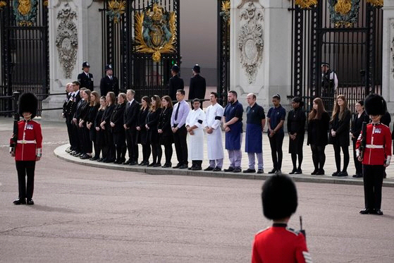 영국 버킹엄궁의 직원들이 19일(현지시간) 엘리자베스 여왕 장례식에서 애도하고 있다. [AP = 연합뉴스]