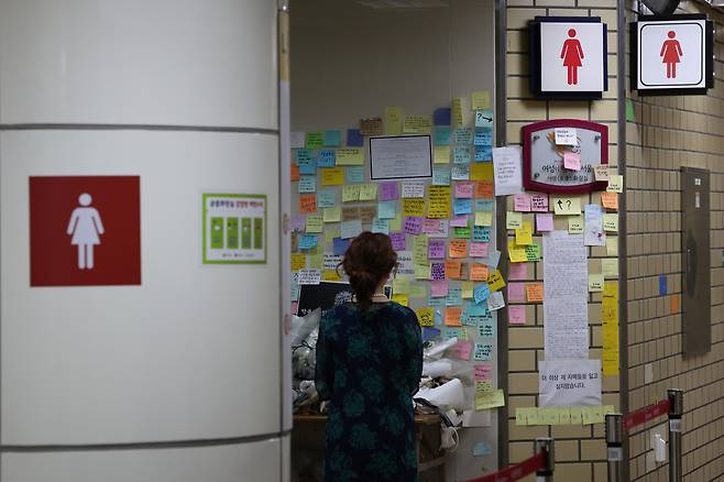'역무원 스토킹 피살 사건'이 발생한 서울 지하철 2호선 신당역에서 20일 오전 한 시민이 여자화장실 입구에 마련된 추모공간을 찾아 고인을 추모하고 있다. [연합]