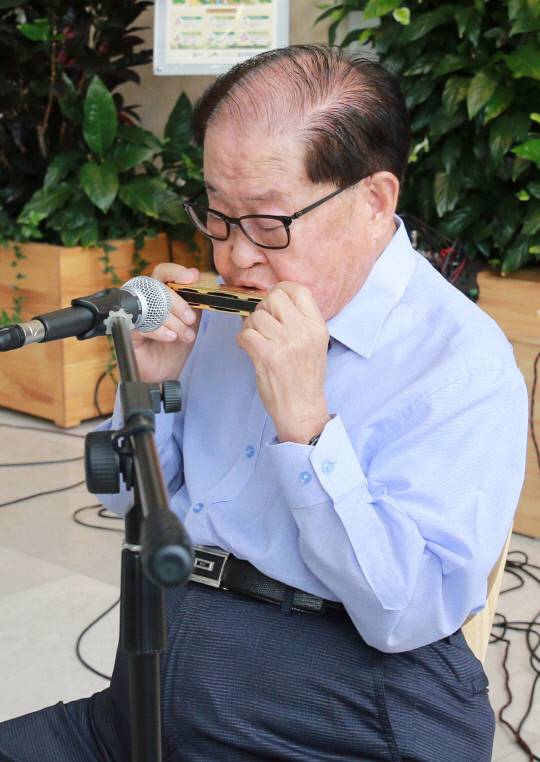 건양교육재단 설립자 겸 명예총장 김희수 박사가 22일 오후 1시 건양대학교병원 로비에서 하모니카 연주를 선보이고 있다. 사진=건양대학교병원 제공