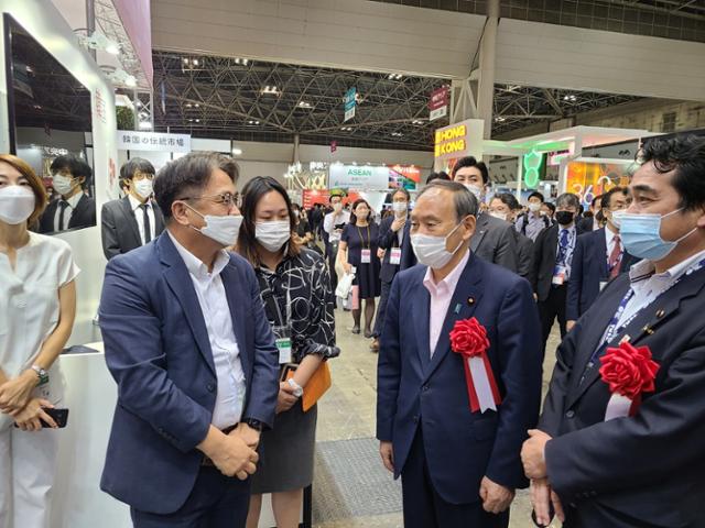 스가 요시히데(오른쪽) 전 일본 총리가 22일 도쿄 빅사이트에서 개막한 ‘투어리즘 엑스포 재팬 2022’의 한국관을 방문해 정진수 한국관광공사 도쿄지사장과 이야기를 나누고 있다. 한국관광공사 도쿄지사 제공