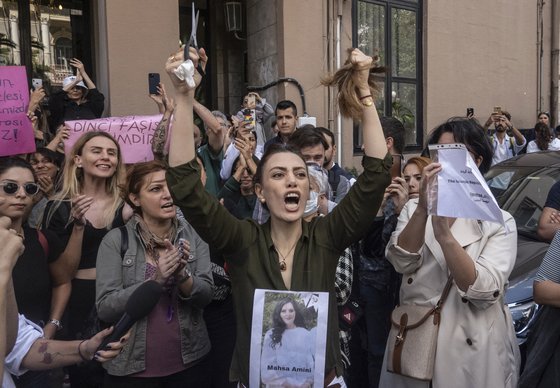 21일(현지시간) 터키 수도 이스탄불에서도 이란 여성의 의문사에 반발하는 시위가 열렸다. 한 여성이 머리카락을 자르며 항의하고 있다. EPA=연합뉴스