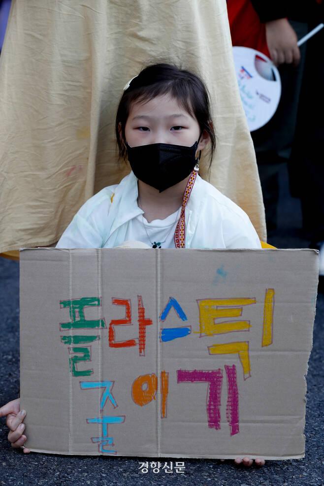 24일 기후정의행진에 참가한 한 어린이가 서울시청 인근에서 플라스틱의 남용에 반대하는 종이팻말을 들고 앉아있다. 문재원 기자