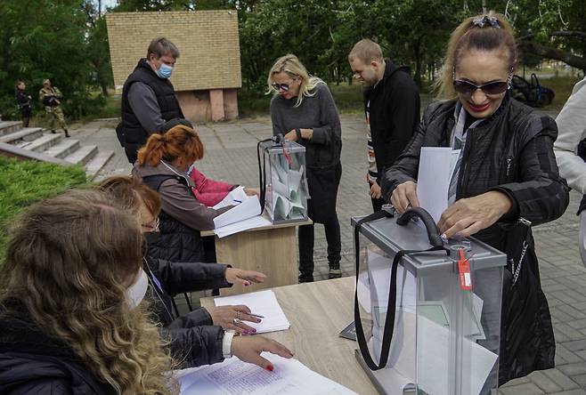 25일(현지시간) 러시아군에 점령된 우크라이나 동부 도시 마리우폴에서 주민들이 러시아 합병 여부를 묻는 투표에 참석한 모습. [EPA]