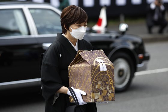 아베 전 총리의 부인 아키에 여사가 27일 오후 유골함을 들고 일본무도관에 도착하고 있다. AP=연합뉴스