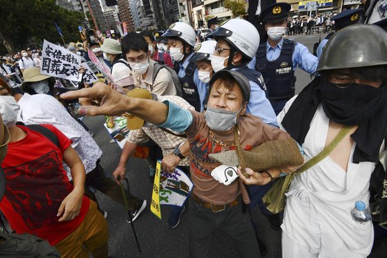 27일 아베 전 총리 국장에 반대하는 시위대가 도쿄 시내에서 구호를 외치고 있다. AP=연합뉴스