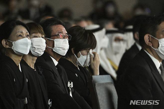 [도쿄=AP/뉴시스] 아베 신조 전 일본 총리의 부인 아키에 여사가 27일 도쿄 닛폰부도칸에서 열린 아베 전 총리의 장례식 중 스크린을 통해 나오는 고인의 모습에 눈물을 흘리고 있다. 2022.09.27.