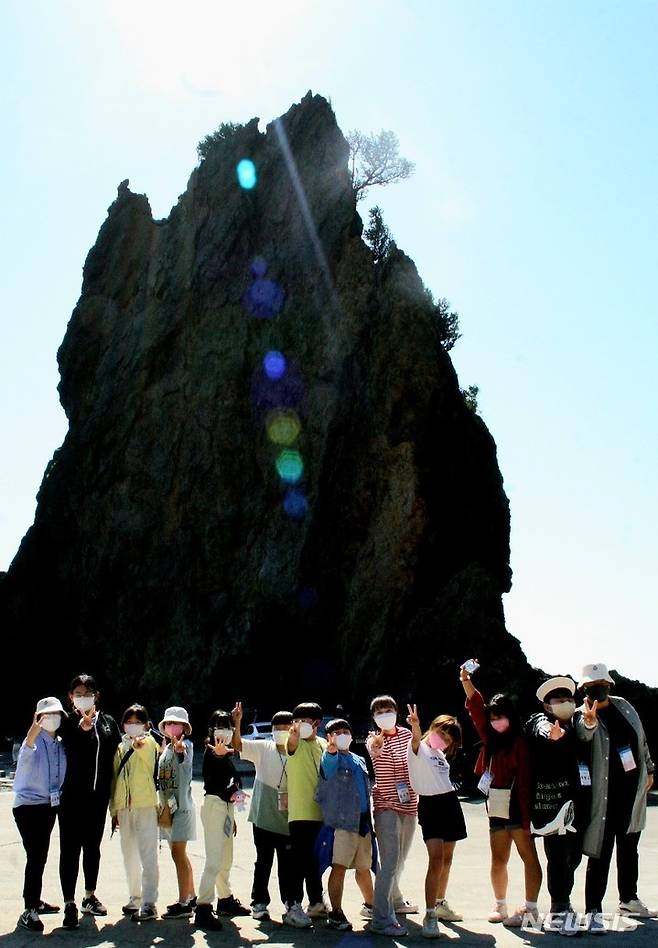 [서울=뉴시스] '아름다운 우리 땅 2022년도 독도탐방' 참가자들이 울릉도 거북바위 앞에서 기념사진을 찍는 모습.