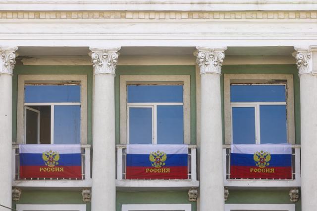 우크라이나 내 러시아 점령지의 러시아 병합이 진행된 30일(현지시간) 러시아로 병합되는 우크라이나 동부 루한스크의 한 건물 외벽에 러시아 국기가 걸려있다. 타스 연합뉴스
