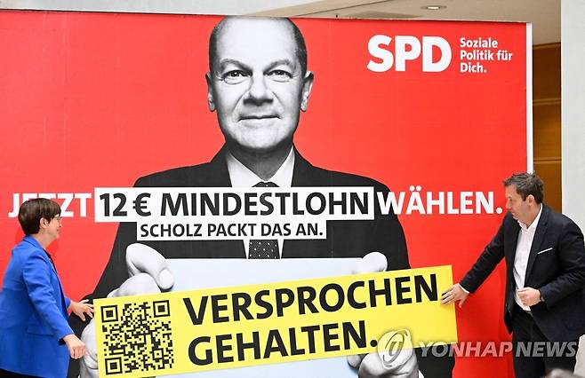 12유로 최저임금을 공약한 올라프 숄츠 독일 총리 포스터에 붙은 "공약 지켰다" 문구  [AFP 연합뉴스 자료사진. 재판매 및 DB 금지]