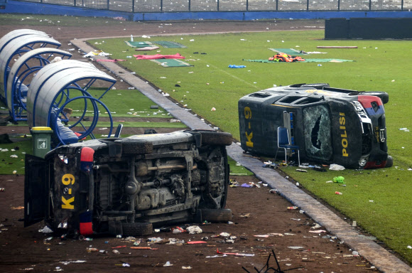 At least 127 people killed during riot following a soccer game in Malang - epa10218863 Damaged police vehicles lay on the pitch inside Kanjuruhan stadium in Malang, East Java, Indonesia, 02 October 2022. At least 127 people including police officers were killed mostly in stampedes after a clash between fans of two Indonesian soccer teams, according to the police. EPA 연합뉴스