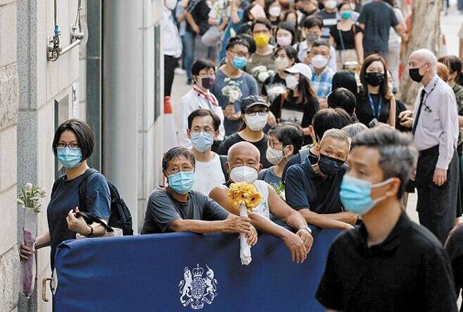 12일(현지시각) 홍콩 주재 영국 총영사관 앞에 엘리자베스 2세 영국 여왕을 추모하려는 홍콩인들이 길게 줄서 있다. 홍콩/로이터 연합뉴스
