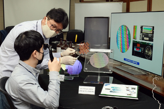 ETRI 연구진이 OLED 디스플레이용 기판을 만들어 설명하고 있다. 사진=ETRI 제공