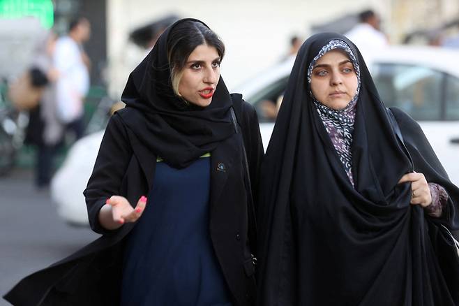 지난 3일(현지시간) 이란의 수도 테헤란에서 히잡을 쓴 여성들이 도로를 걷고 있다. 이란에서는 지난달 13일 마흐사 아미니(22세)라는 여성이 히잡을 적법하게 착용하지 않았다는 이유로 풍속 단속 경찰에게 체포된 뒤 16일 의문사하자 고인을 추모하고 진상 규명을 요구하는 시위가 일어나고 있다. 로이터연합뉴스