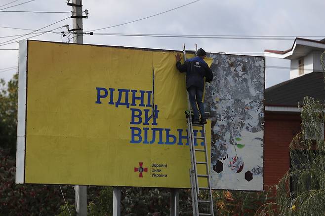 3일(현지시간) 우크라이나군이 러시아군으로부터 탈환한 우크라이나 북동부 하르키우주(州) 쿠피안스크시(市)에 ‘우크라이나 시민 당신들은 모두 자유’란 문구가 적힌 광고판이 설치되고 있다. [EPA]