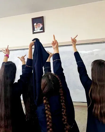 이란의 전 최고지도자였던 아야톨라 루홀라 호메이니와 현 최고지도자인 알리 호세인 하메네이의 사진을 향해 손가락 욕을 하는 여학생들.(트위터 갈무리)