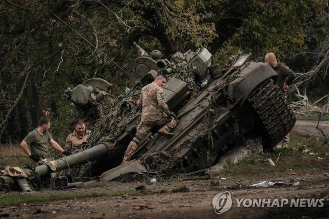 하르키우를 수복한 뒤 버려진 러시아군 전차에서 부품을 뜯는 우크라이나군 병사들 [AFP 연합뉴스자료사진. 재판매 및 DB 금지]