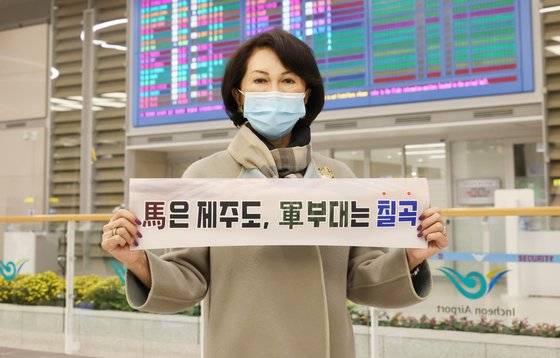 인천공항에 도착한 백남희 여사가 대구지역 군부대 유치 관련 현수막을 펼쳐 보이고 있다. 칠곡군