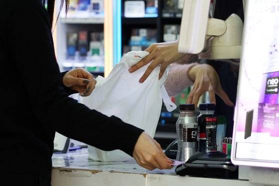 20일 오후 서울 시내 한 편의점에서 고객이 일회용 봉투에 물건을 담아가고 있다. 한 달 뒤인 다음 달 24일부터는 편의점 일회용 봉투 등 일회용품 사용이 전면 제한된다. 뉴시스