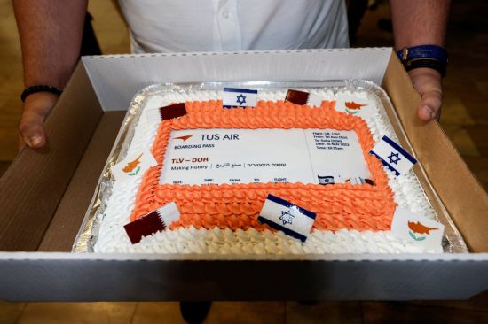 20일(현지시간) 이스라엘 텔아비브 벤 구리온 공항에서 한 남성이 이스라엘과 카타르 간 첫 직항편을 기념하며 만든 케이크를 들고 있다. 사진=로이터연합뉴스
