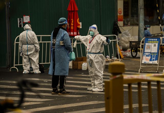 코로나19 확산을 막기 위해 차단된 중국 베이징의 한 주거단지 앞에 지난 22일 방호복을 입은 요원들이 서 있다. AFP연합뉴스