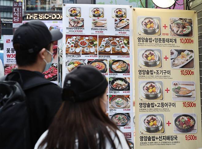 지난달 10일 서울 중구 명동의 한 음식점 메뉴판을 보고 있는 소비자들 모습. [사진 출처 = 연합뉴스]