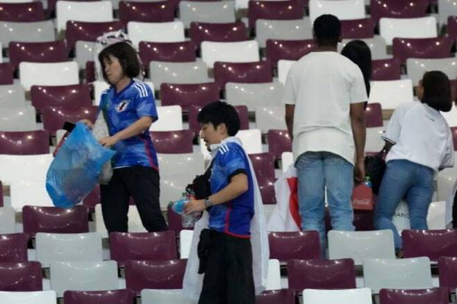 23일(한국시간) 일본이 독일을 꺾은 경기 후 경기장을 청소하는 일본 팬들의 모습. 알라이얀(카타르)=AP뉴시스