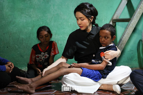 윤석열 대통령 부인 김건희 여사가 지난 12일 캄보디아 프놈펜에서 선천성 심장질환을 앓고 있는 14세 아동의 집을 찾아 건강 상태를 살피며 위로하고 있다. 대통령실 홈페이지