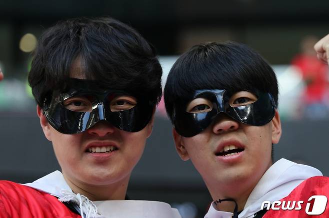 (도하(카타르)=뉴스1) 이동해 기자 = 24일 오후(현지시간) 카타르 알라이얀 에듀케이션 시티 스타디움에서 열리는 2022 카타르 월드컵 조별리그 H조 1차전 우루과이와의 경기를 찾은 축구팬들이 캡틴 손흥민이 착용한 안면 마스크를 착용한 채 취재진을 바라보고 있다. 2022.11.24/뉴스1 Copyright (C) 뉴스1. All rights reserved. 무단 전재 및 재배포 금지.