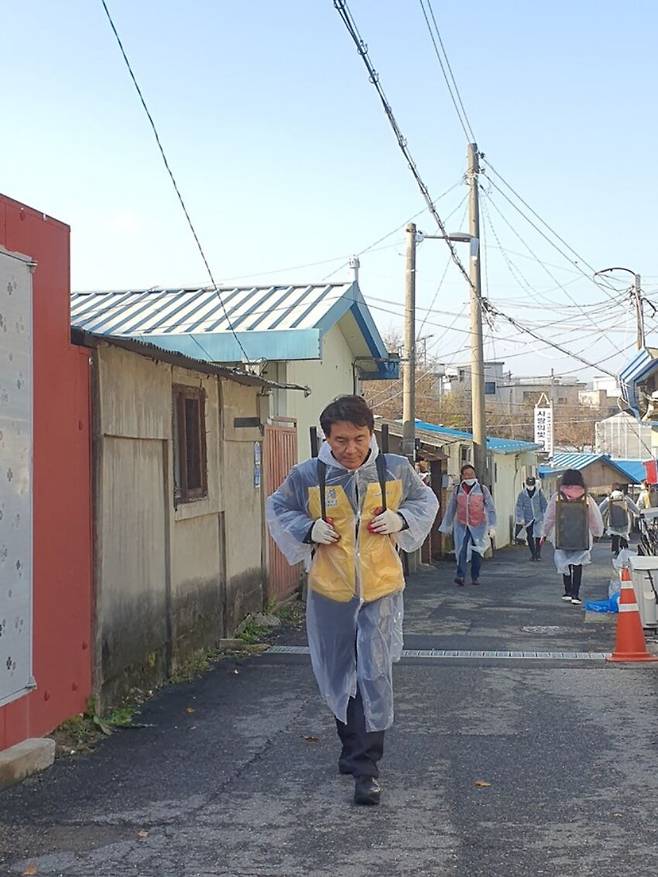 26일 지게에 연탄을 짊어지고 언덕을 오르고 있는 김진태 강원도지사.