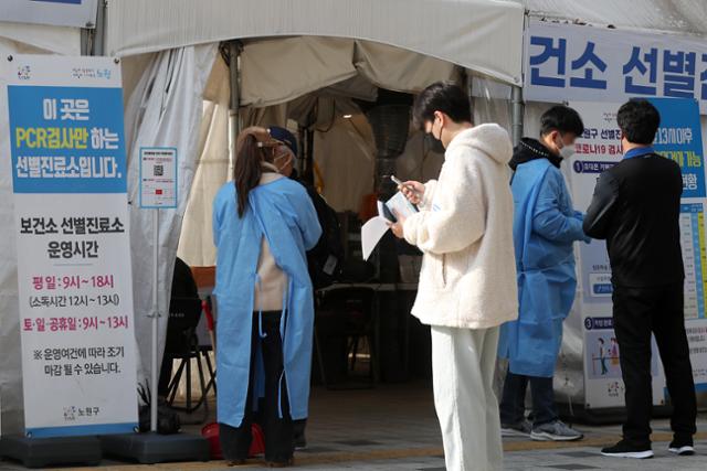 25일 서울 노원구보건소에 마련된 신종 코로나바이러스 감염증(코로나19) 선별진료소에서 시민들이 의료진과 문답을 나누고 있다. 뉴스1