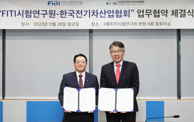김화영 FITI시험연구원장(왼쪽)과 박재홍 한국전기차산업협회장이 협약을 체결한 후 협약서를 들어보이고 있다.
