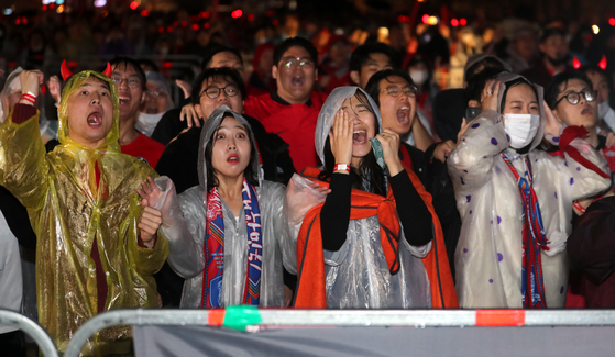 Braving the rain, crowds cheer for Team Korea as they watch it play against Ghana in Gwanghwamun Square in central Seoul late Tuesday. Korea was beaten 3-2 by Ghana in their second Group H match of the 2022 World Cup. [NEWS1]