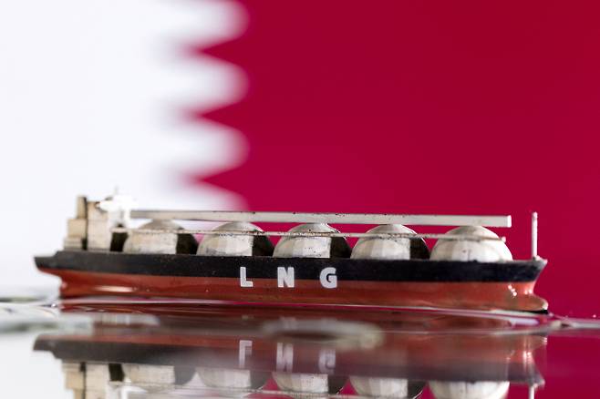 카타르 국기와 LNG선 모형을 함께 배치한 사진.