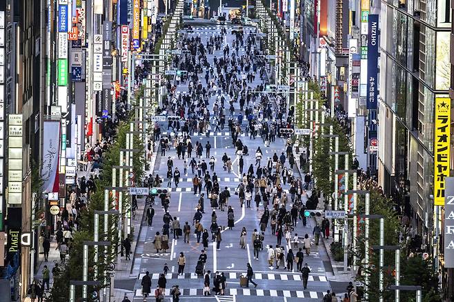 일본 도쿄의 번화가인 긴자 지구에서 행인들이 해질 무렵의 거리를 오가고 있다.