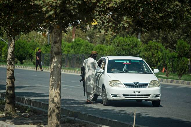 아프가니스탄 수도 카불의 러시아 대사관 인근에서 탈레반 대원이 차량을 검문하고 있다.