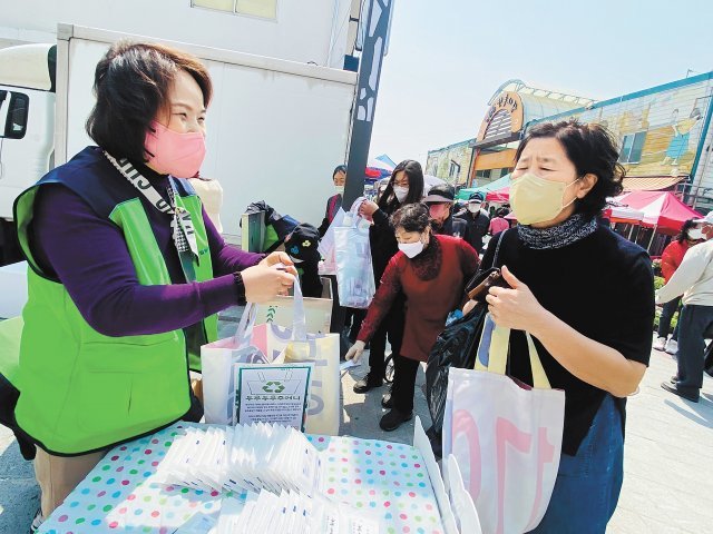 폐현수막 업사이클링 가방을 나눠주는 봉사자. 철원군자원봉사센터 제공
