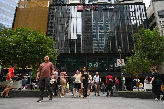 지난달 6일 싱가포르의 금융 중심지인 래플스 플레이스 지역에서 회사원들이 점심 시간에 건물을 나서고 있다.AFP연합뉴스