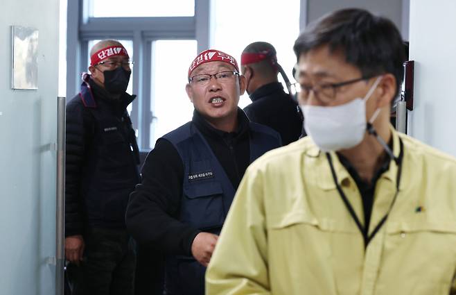 Ministry of Land, Infrastructure and Transport Director Koo Heon-sang walks out of meeting room in Sejong City, while Cargo Truckers Solidarity rep. Kim Tae-young shouts in protest. Second talk to resolve issue over minimum freight rate policy failed again on Wednesday. (Yonhap)