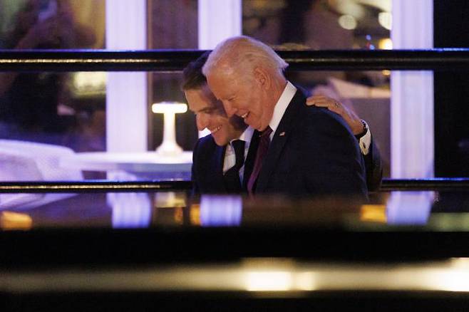 얼굴은 웃지만… 미국을 방문한 에마뉘엘 마크롱 프랑스 대통령(뒤쪽)이 30일(현지시간) 조 바이든 미국 대통령과 어깨동무를 하고 웃으며 대화를 나누고 있다. 워싱턴 | UPI연합뉴스