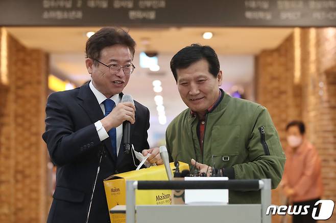 지난 10월 26일 오후 6시쯤 경북 봉화군 아연광산 붕괴 사고로 매몰됐다가 221시간 만에 '기적의 생환'을 이뤄낸 광부 2명이 11일 오전 경북 안동병원에서 퇴원했다. 작업반장 박정하씨(62)가 퇴원을 앞두고 병원 로비에서 열린 기자회견을 통해 소감을 밝히던 중 커피믹스를 가지고 온 사람 없냐며 농담을 건네자 이철우 경북도지사가 믹스커피를 상자째 건네고 있다. ⓒ News1 공정식 기자