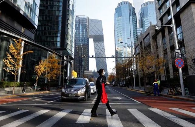 코로나19가 재확산하고 있는 중국 베이징 중심지 차오양구에서 한 여성이 21일 오전 러시아워에도 한산한 도로를 건너가고 있다. ⓒ 로이터/연합뉴스