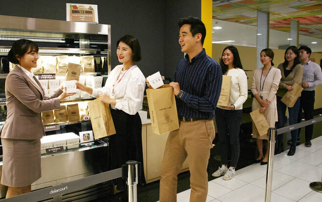 수원 삼성 디지털시티 사내 식당에서 임직원들이 테이크아웃 음식이 담긴 재생종이 봉투를 들고 있다. [자료:삼성전자 뉴스룸]