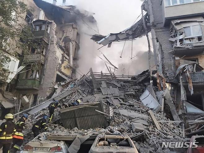 [자포리자=AP/뉴시스] 6일(현지시간) 우크라이나 남부 자포리자 주거지 건물이 러시아의 미사일 공격으로 파괴돼 소방관들이 작업하고 있다. 현지 당국은 러시아군이 밤사이 미사일 7발을 쏴 2명이 숨지고 최소 5명이 잔해에 갇혔다고 밝혔다. 2022.10.06