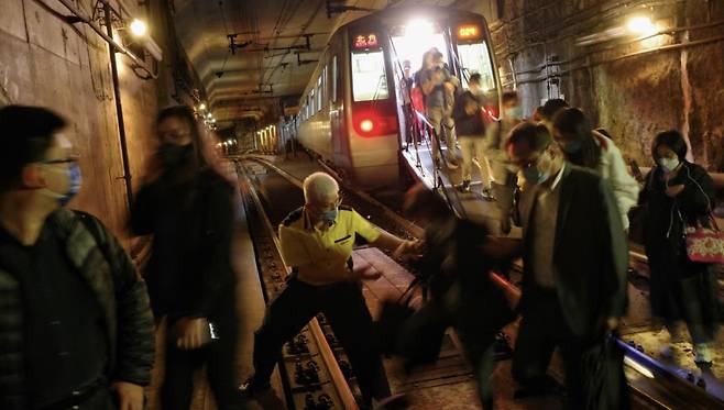 현지시각 5일 오전 8시30분께 발생한 지하철 장비 결함 사고로 출근길 홍콩 시민들이 터널을 통해 대피하고 있다.[SCMP]