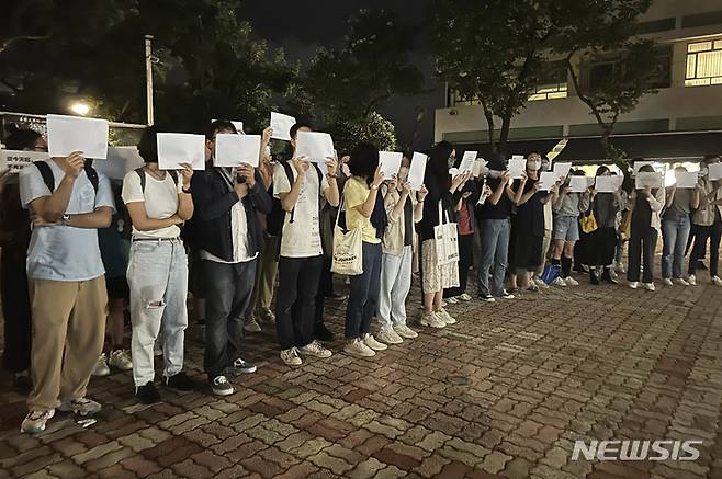 [홍콩=AP/뉴시스]시위자들이 28일 홍콩 중문대학교에서 최근 발생한 우루무치 화재 희생자들을 추모하는 집회 동안 백지를 들고 있다. 2022.11.29