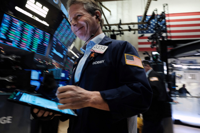 한 트레이더가 미국 뉴욕증권거래소(NYSE)에서 웃는 얼굴로 업무를 보고 있다. AFP연합뉴스
